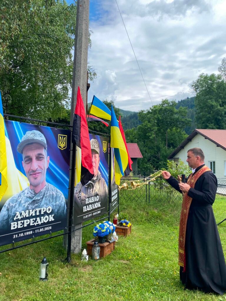 Чоловік у рясі отця хитає кадилом перед банером з обличчям чоловіка