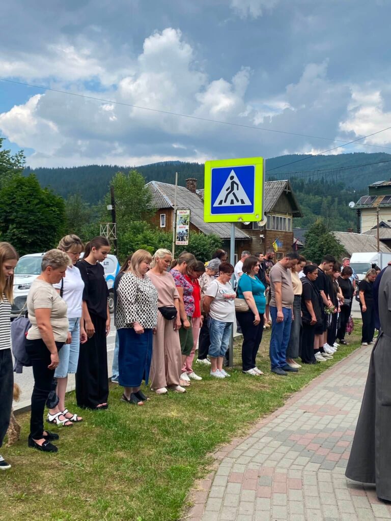 Люди стоять зі схиленими головами